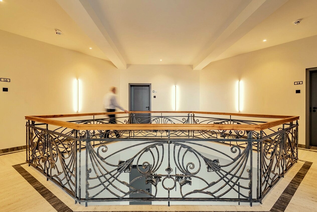 Galerie im Obergeschoss mit Jugendstil-Geländer, eine Person geht mit Bewegungsunschärfe vorbei — Visualisierung, Person nachträglich eingesetzt