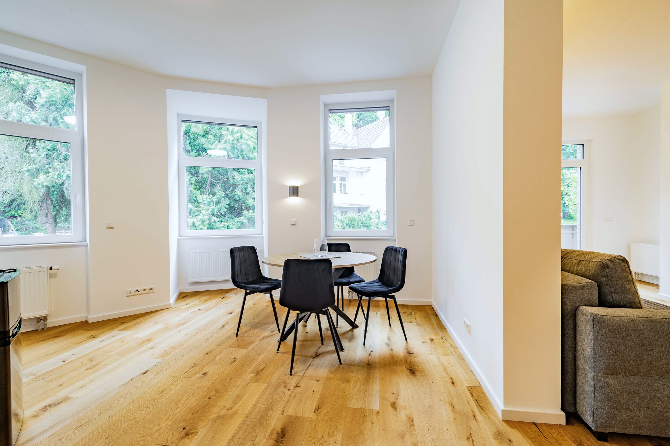 Bewohntes Apartment mit Sofa, Esstisch und Erkerfenster